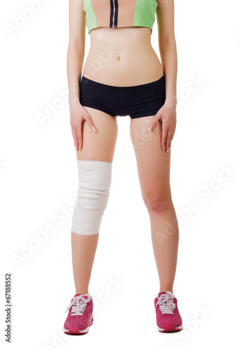 Athletic young woman with elastic bandage on his leg. Isolated