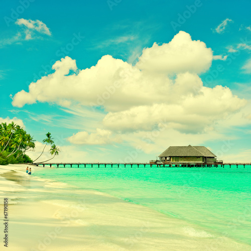 tropical island beach with turqiuse water and blue sky
