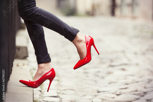Woman wearing black leather pants and red high heel shoes