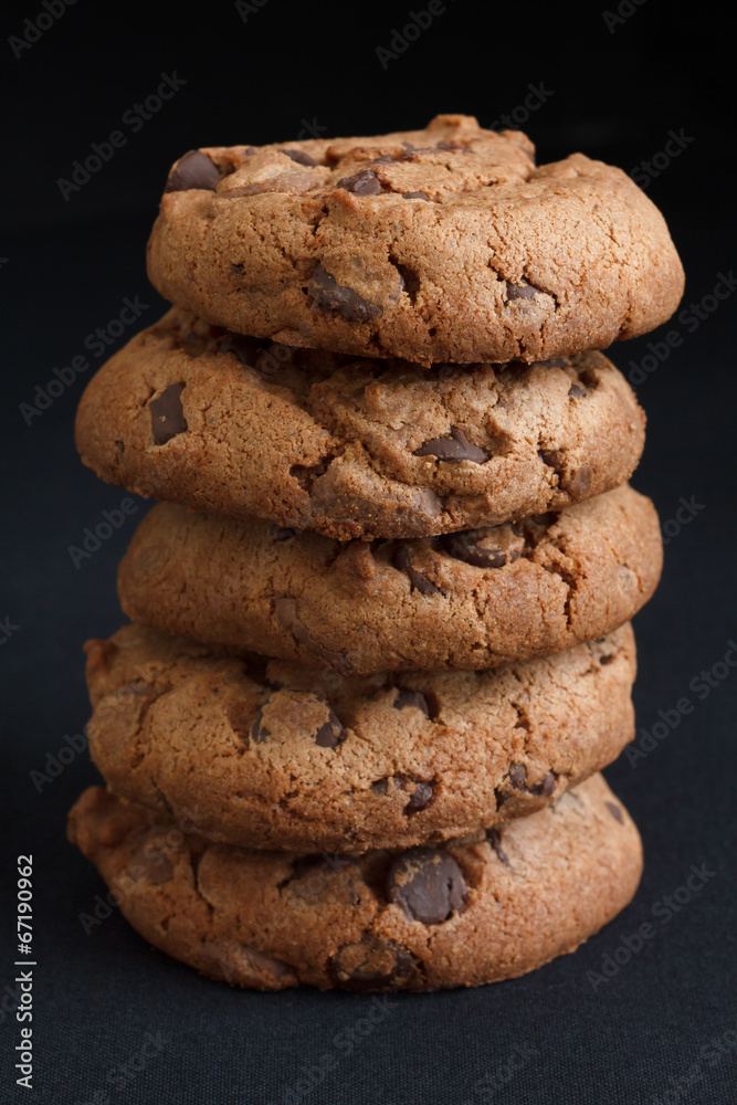 Stack of chocolate chip cookies on dark grey fabric. Stack of chocolate chip cookies on dark grey fabric.