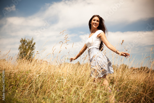 Attractive happy woman joying in beautiful summer day.