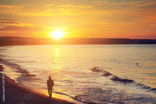 Man walking alone on the beach at sunset. Calm sea © Photocreo Bednarek