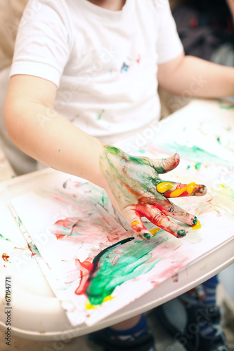 Boy painting with finger-paints