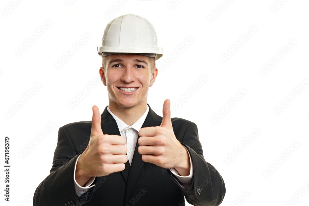 Young businessman in a protective helmet show you thumbs up Young businessman in a protective helmet show you thumbs up