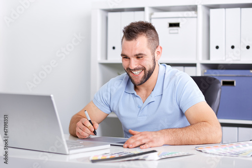 Graphic designer using a graphics tablet in a modern office