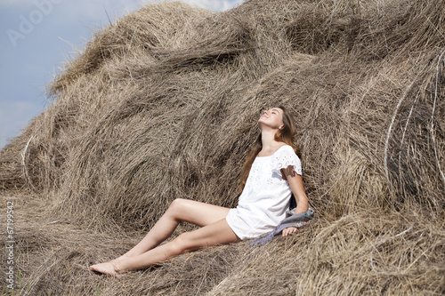 Young beautiful woman in the hayloft in the village