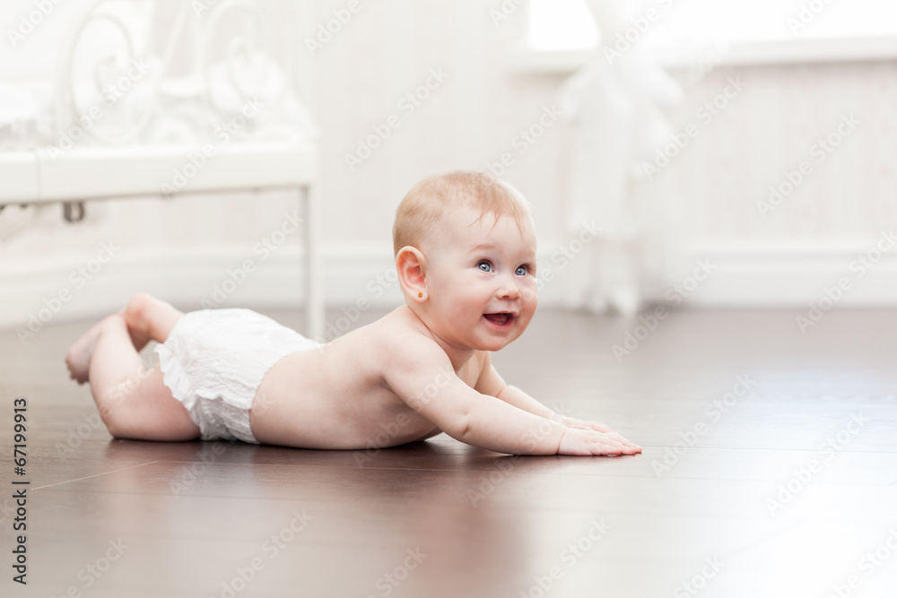 Happy seven month old baby girl crawling on a hardwood floor Happy seven month old baby girl crawling on a hardwood floor