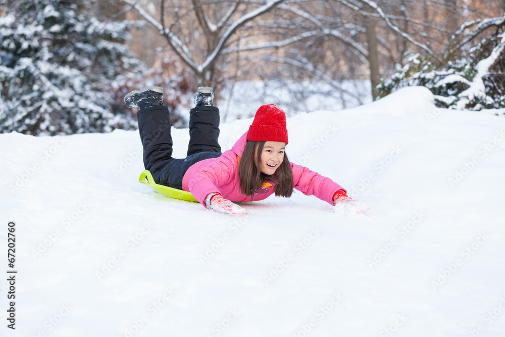 girl sliding on snow from hill fast.