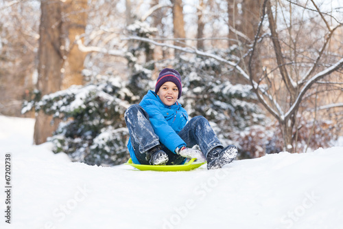 boy sitting on sledges and sliding down.