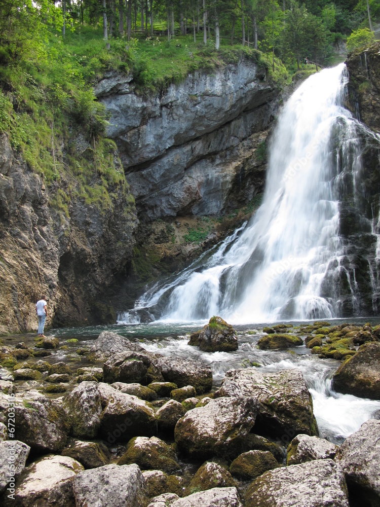 Fototapeta premium mann steht am wasserfall