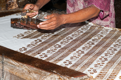 Man stamping batik in workshop
