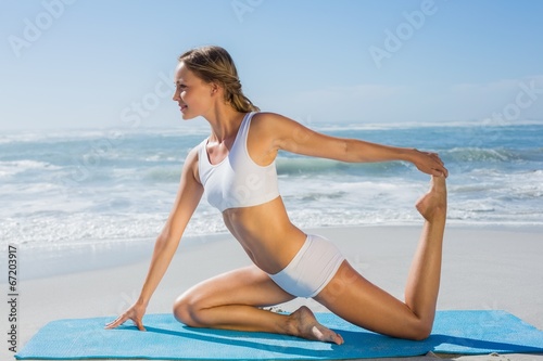 Gorgeous fit blonde in seated yoga pose on the beach © WavebreakMediaMicro