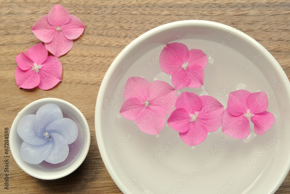 Flowers in a water bowl for aromatherapy on a wooden background