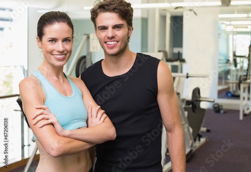 Fit man and woman smiling at camera together