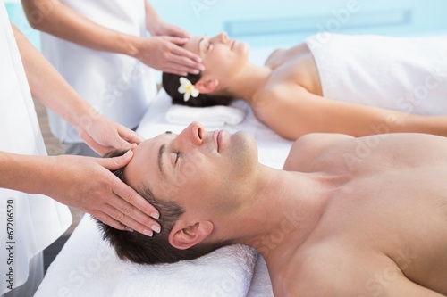 Content couple enjoying head massages poolside