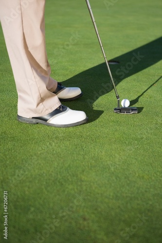 Golfer putting ball on the green