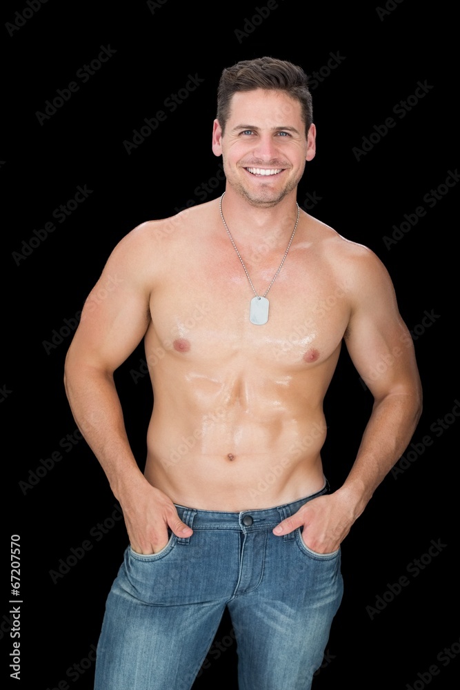 Obraz premium Handsome muscular man posing in blue jeans smiling at camera
