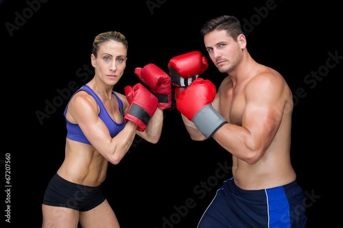 Bodybuilding couple posing with boxing gloves looking at camera © WavebreakmediaMicro