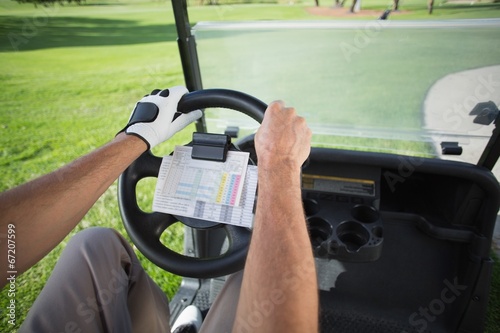 Golfer driving his golf buggy forward