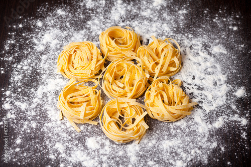 Raw pasta tagliatelle on table