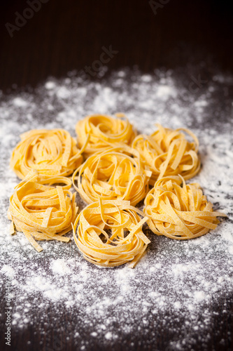 Raw pasta tagliatelle on table