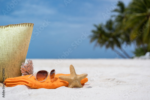 Fototapeta Naklejka Na Ścianę i Meble -  Summer beach bag with coral,towel,sunglasses and flip flops