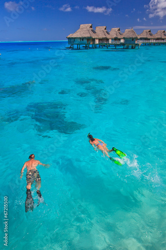 Couple snorkeling in the blue lagoon, Bora Bora, South Pacific