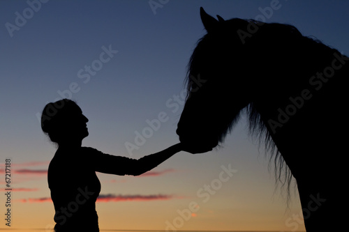 Silhouette girls and horses at sunset