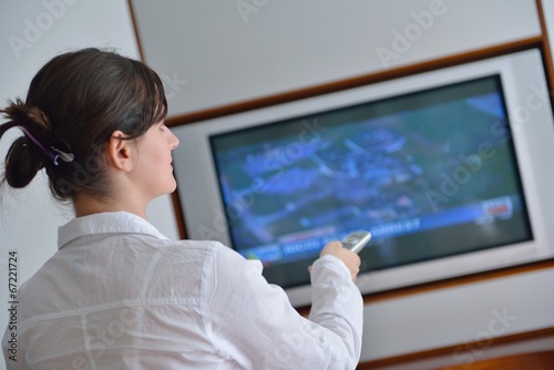 young woman watching tv at home