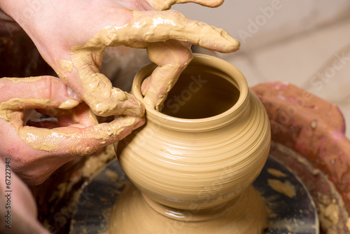 hands of a potter, creating an earthen jar