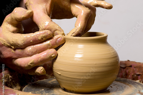 hands of a potter, creating an earthen jar