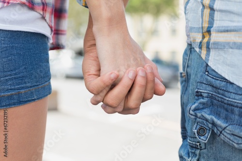 Couple in check shirts and denim holding hands