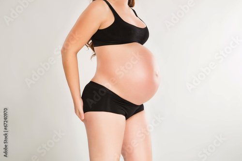 Pregnant woman in black underware studio shot