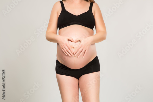 Pregnant women wrap her arms around the belly in the form of the