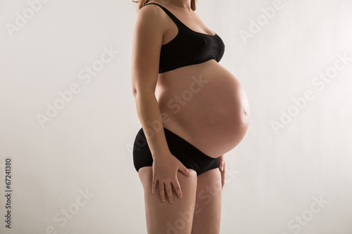 Pregnant woman in black underware studio shot