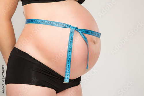 Pregnant woman with ruller posing in studio