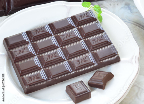 tabliczka ciemnej czekolady na białym talerzyku