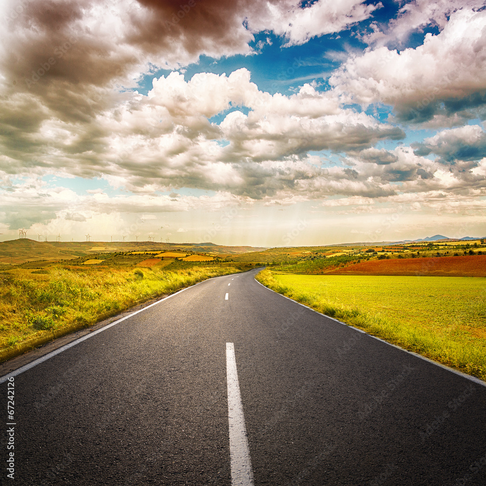 Fototapeta premium Scenery of asphalt road through agricultural fields
