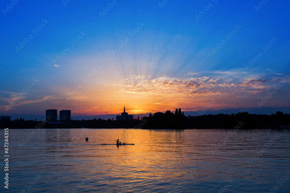man in kayaking on Lake at sunset