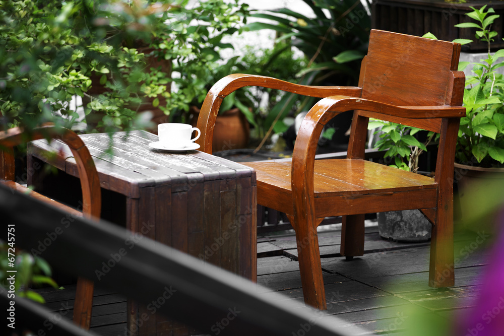 close up white cup and wooden chair in garden