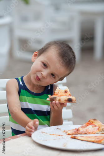 Adorable boy, eating pizza