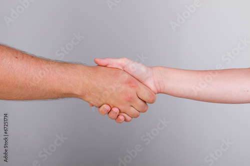 Hand shake between a man and a woman isolated on grey