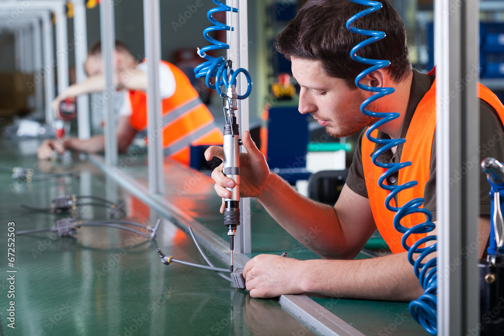 Foto Men during precision work on production line