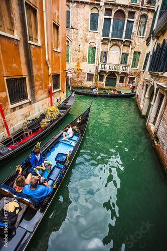 Tourists travel on gondolas at canal