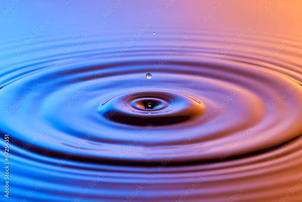 Water drop close up with concentric ripples colourful blue and a Water drop close up with concentric ripples colourful blue and a