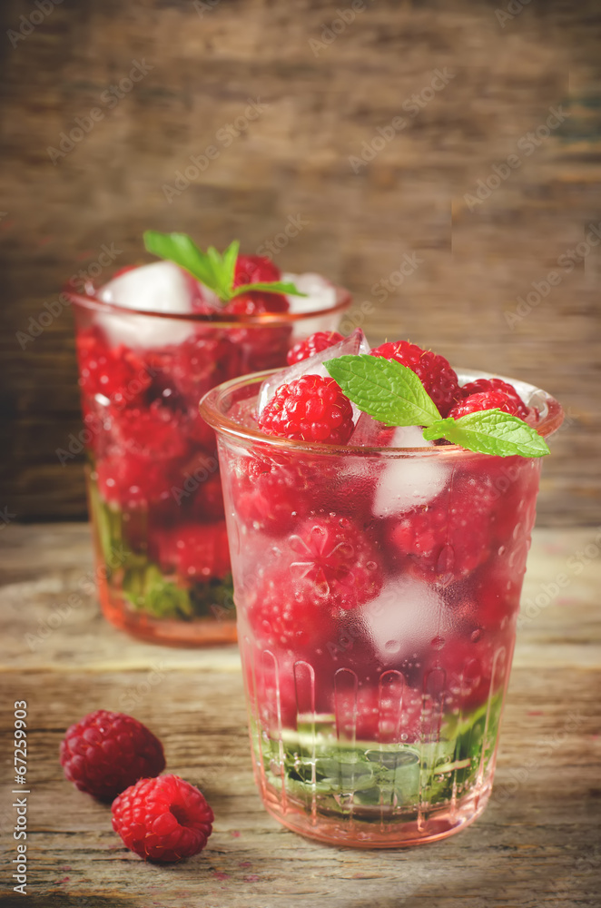 Summer juice with fresh raspberries mint and ice in a glass Summer juice with fresh raspberries mint and ice in a glass