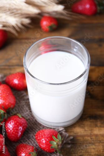 Ripe sweet strawberries and glass with milk