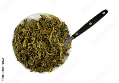 Cooked collard greens in a small dish with a fork