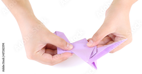 Hands making origami toy  close up  isolated on white