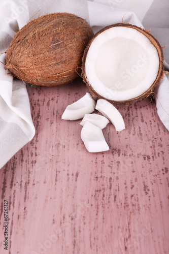 Broken coconut with napkin on wooden background